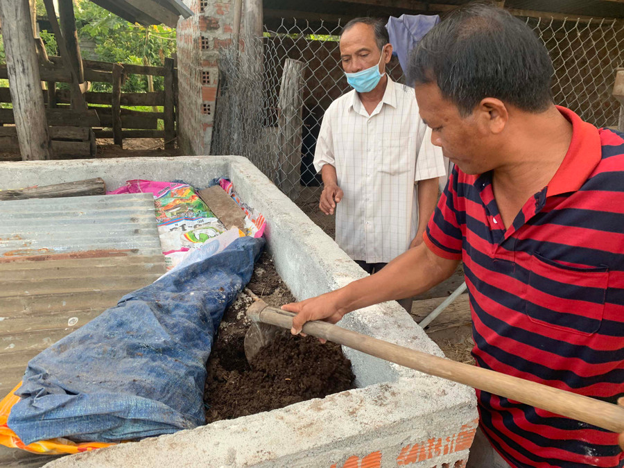 Ông Ksor Trim (bìa phải; buôn Tơ Khế, xã Ia Tul, huyện Ia Pa) kiểm tra bể ủ phân hữu cơ. Ảnh: Vũ Chi