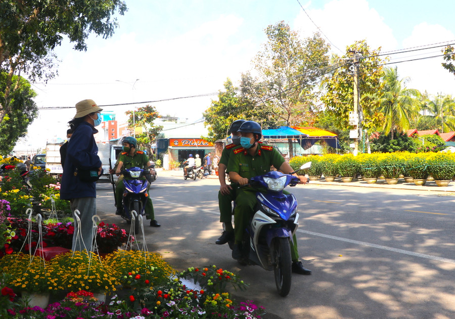 Công an phường Tây Sơn (thị xã An Khê) nhắc nhở người dân buôn bán đảm bảo an ninh trật tự tại chợ hoa Tết. Ảnh: Ngọc Minh