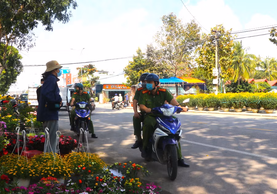 Công an phường Tây Sơn (thị xã An Khê) nhắc nhở người dân buôn bán đảm bảo an ninh trật tự tại chợ hoa Tết. Ảnh: Ngọc Minh