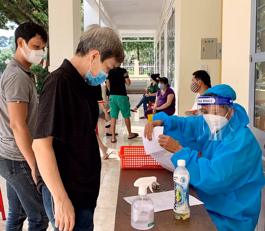  Người dân khai báo y tế trước khi tiêm vắc xin phòng Covid-19. Ảnh: Như Nguyện