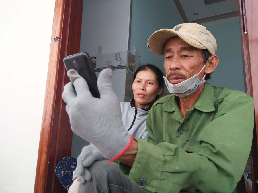 Hình ảnh: Ông Sanh và bà Cam nói chuyện với chiến sĩ Nguyễn Thành Nhân qua điện thoại. Ảnh: Hà Duyệt