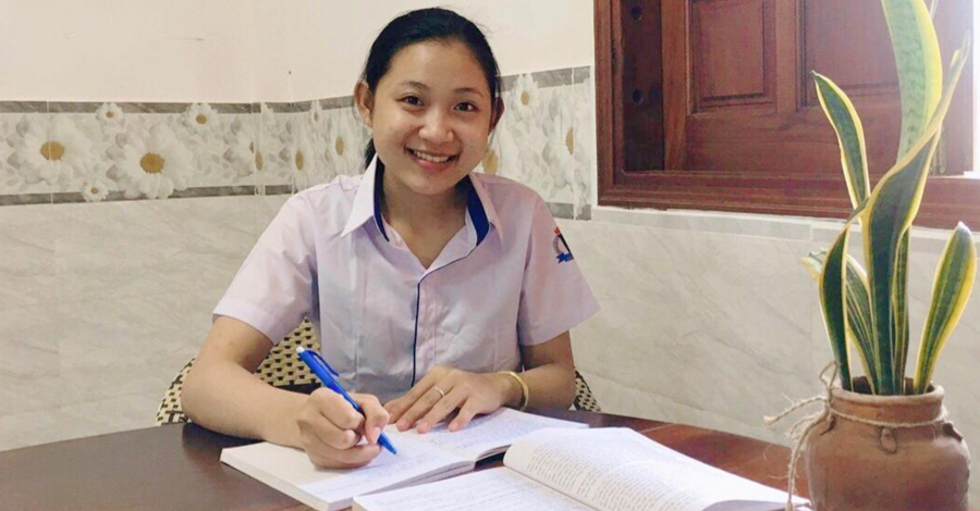 Trang tranh thủ ôn bài trước khi đi trao quà. Ảnh: NVCC