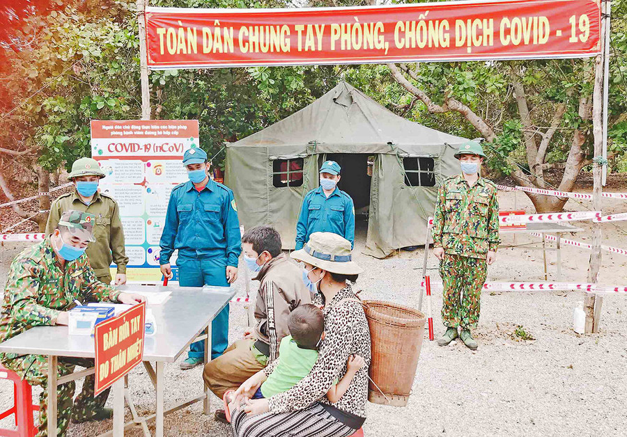 Hướng dẫn người dân vùng biên giới thực hiện các biện pháp phòng dịch- Ảnh Lê Quang