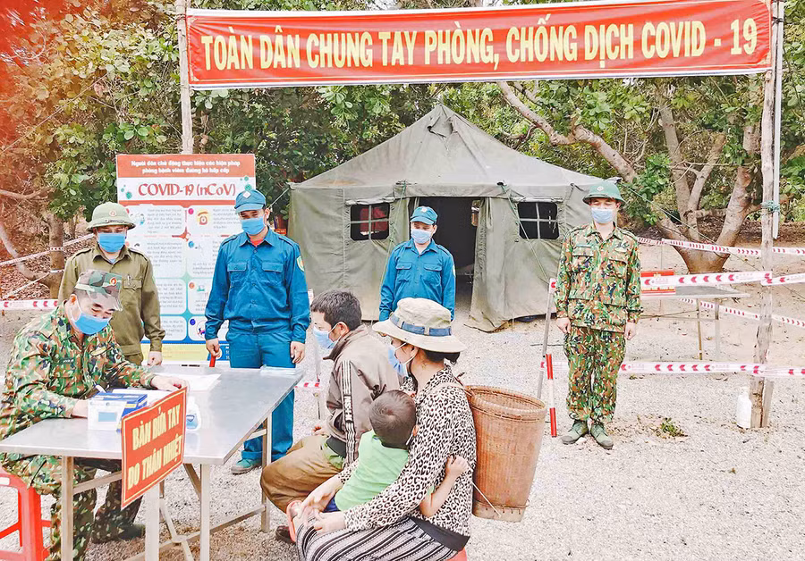 Hướng dẫn người dân vùng biên giới thực hiện các biện pháp phòng dịch- Ảnh Lê Quang