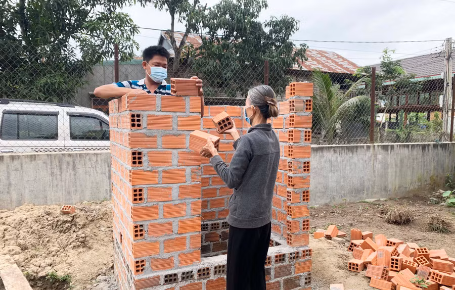 Gia đình bà Nay H’Kih (buôn Plei Apa Ama Đă) hỗ trợ đơn vị thi công ngày công, nguyên vật liệu để xây dựng nhà tiêu hợp vệ sinh. Ảnh: Nguyên Hương