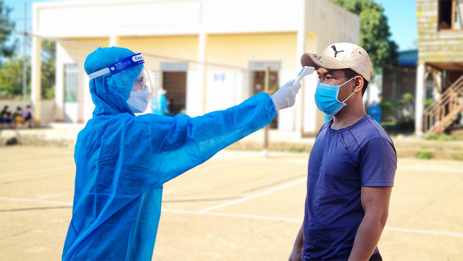 Kiểm tra thân nhiệt người dân trước khi lấy mẫu test nhanh Covid-19 tại làng Ia Lang (phường Chi Lăng, TP. Pleiku). Ảnh: Bá Bính