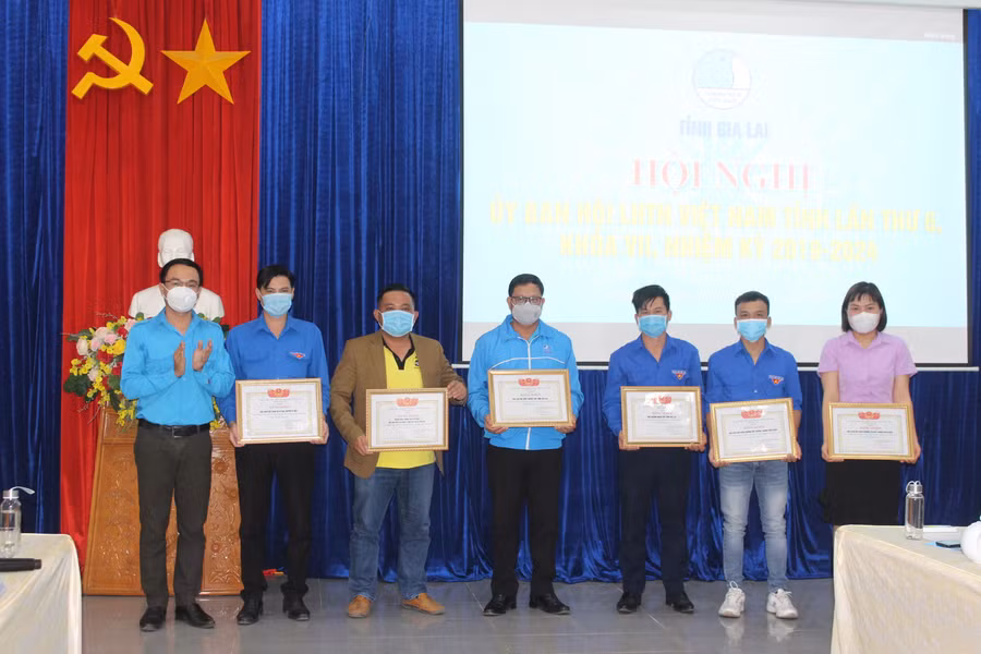 Anh Đỗ Đức Thanh (bìa trái)-Phó Bí thư Tỉnh Đoàn, Phó Chủ tịch Hội LHTN Việt Nam tỉnh tặng bằng khen cho các tập thể có thành tích xuất sắc trong công tác Hội và phong trào thanh niên năm 2021. Ảnh: Phan Lài