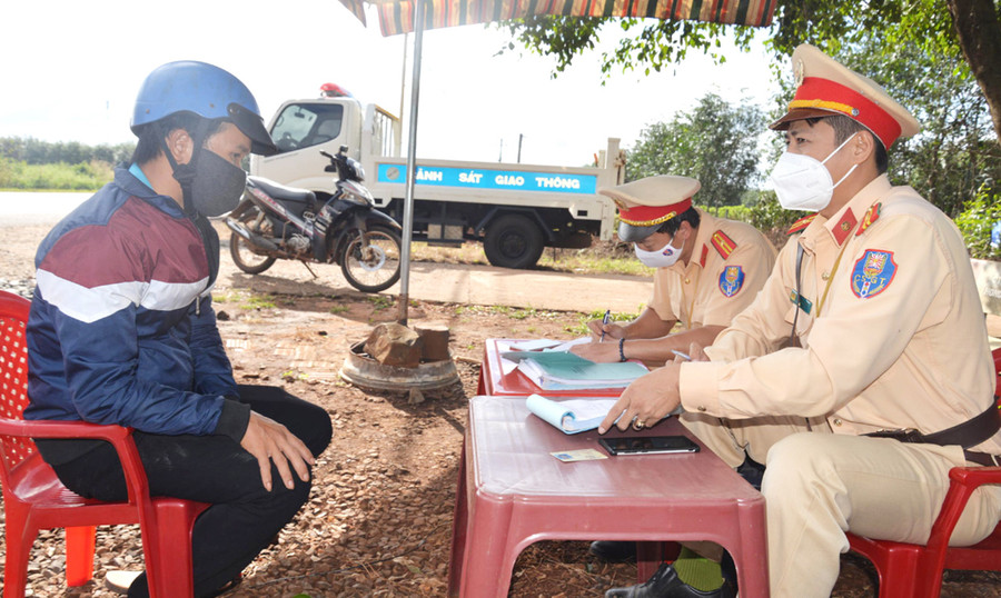 Cán bộ Phòng Cảnh sát Giao thông (Công an tỉnh) lập biên bản xử phạt người vi phạm Luật Giao thông đường bộ. Ảnh: Nguyễn Hữu