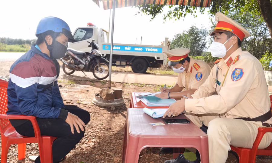 Cán bộ Phòng Cảnh sát Giao thông (Công an tỉnh) lập biên bản xử phạt người vi phạm Luật Giao thông đường bộ. Ảnh: Nguyễn Hữu