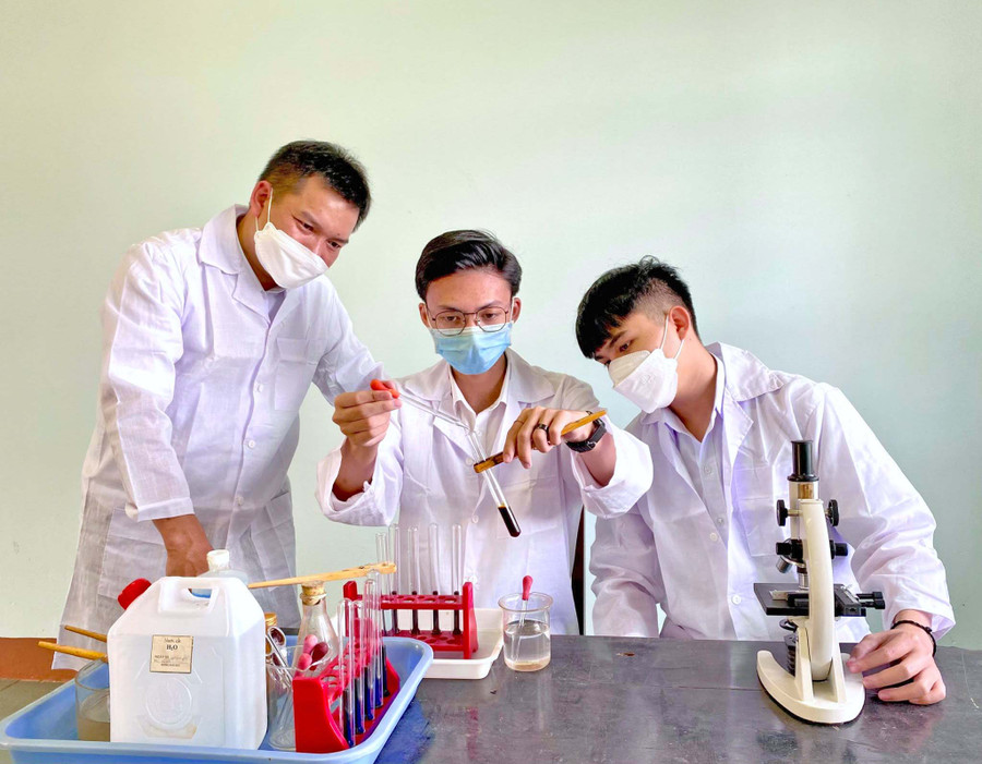 Em Huỳnh Lê Nhật Tiến (bìa phải), Phan Huỳnh Xuân Win (giữa) cùng thầy giáo Lương Văn Tri trong 1 giờ thực hành thí nghiệm tại Trường THPT Lê Lợi. Ảnh: Mộc Trà