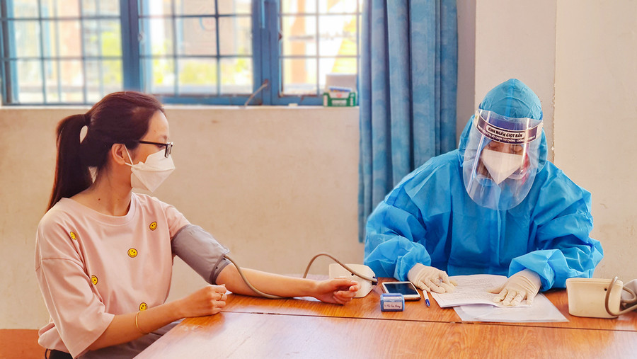 Nhân viên y tế kiểm tra sức khỏe người dân trước khi tiêm mũi 3 vắc xin phòng Covid-19. Ảnh: Bá Bính  Nhân viên y tế kiểm tra sức khỏe người dân trước khi tiêm mũi 3 vắc xin phòng Covid-19. Ảnh: Bá Bính