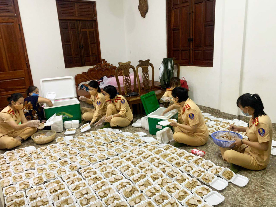 Nữ cán bộ, chiến sĩ Phòng Cảnh sát Giao thông (Công an tỉnh) chuẩn bị các phần xôi hỗ trợ người dân từ phía Nam trở về qua địa bàn tỉnh. Ảnh: Lê Anh