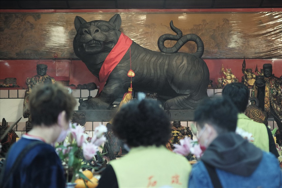  Người dân địa phương cầu nguyện trước bức tượng thần hổ ở thành phố Tân Đài Bắc, Đài Loan (Trung Quốc) vào ngày 28.1, trước Tết Nhâm Dần 2022. Ảnh: AFP