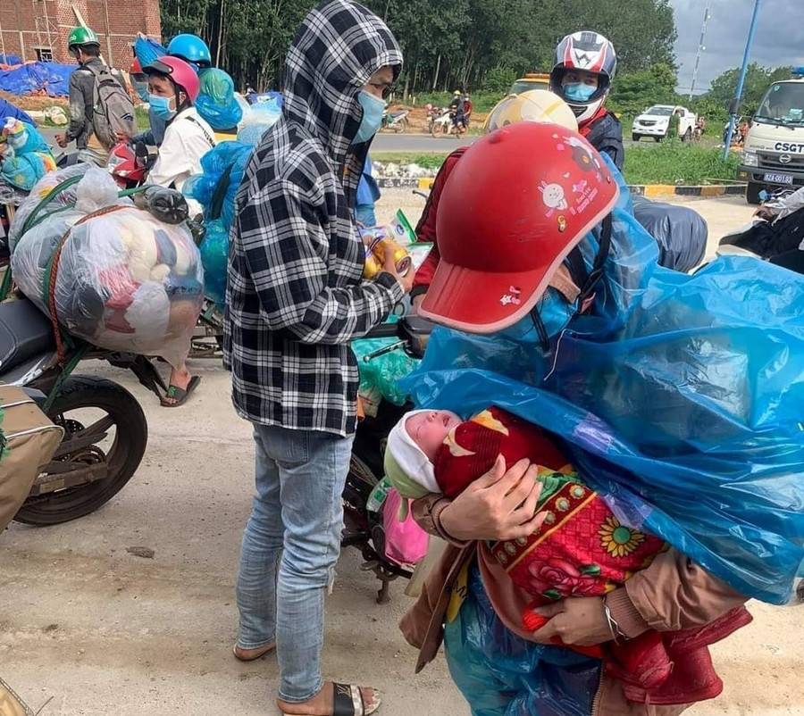 Chị Lầu Y Tránh và đứa con 7 ngày tuổi trên đường “chạy dịch” về quê. Ảnh: M.X.H