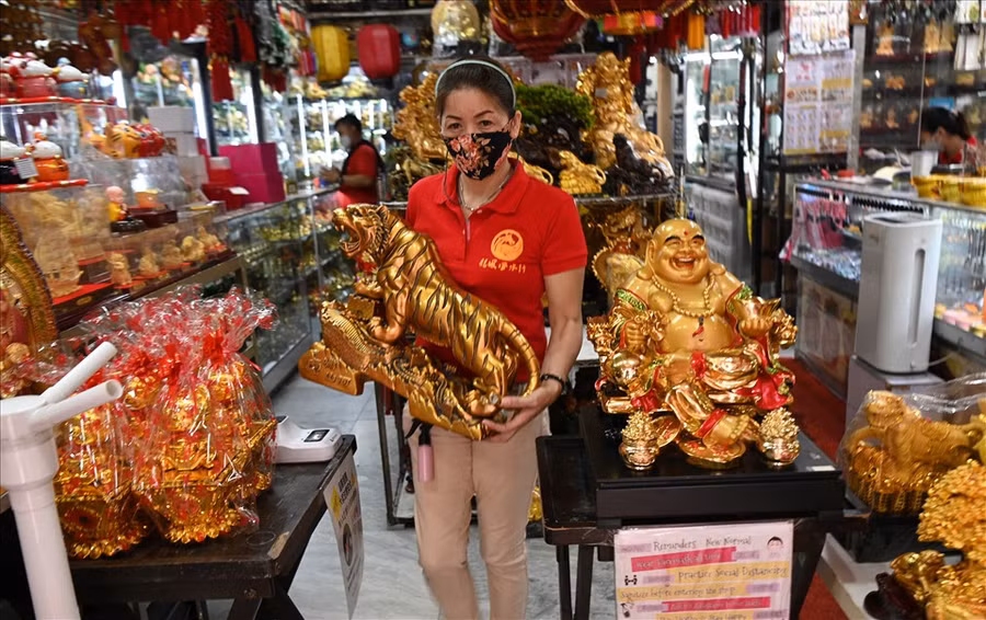 Một người bán hàng mang bức tượng hổ bày bán ở khu Chinatown của Manila, Philippines ngày 28.1, chỉ vài ngày trước Tết Nhâm Dần 2022. Ảnh: AFP