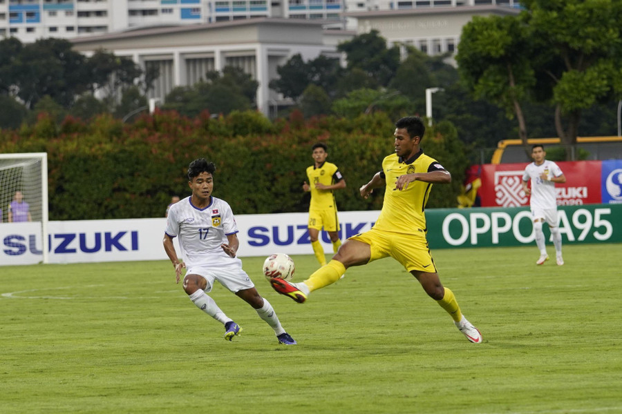 Trận Lào (trái) thua đậm Malaysia cũng bị bàn tán bán độ. Ảnh: LFF