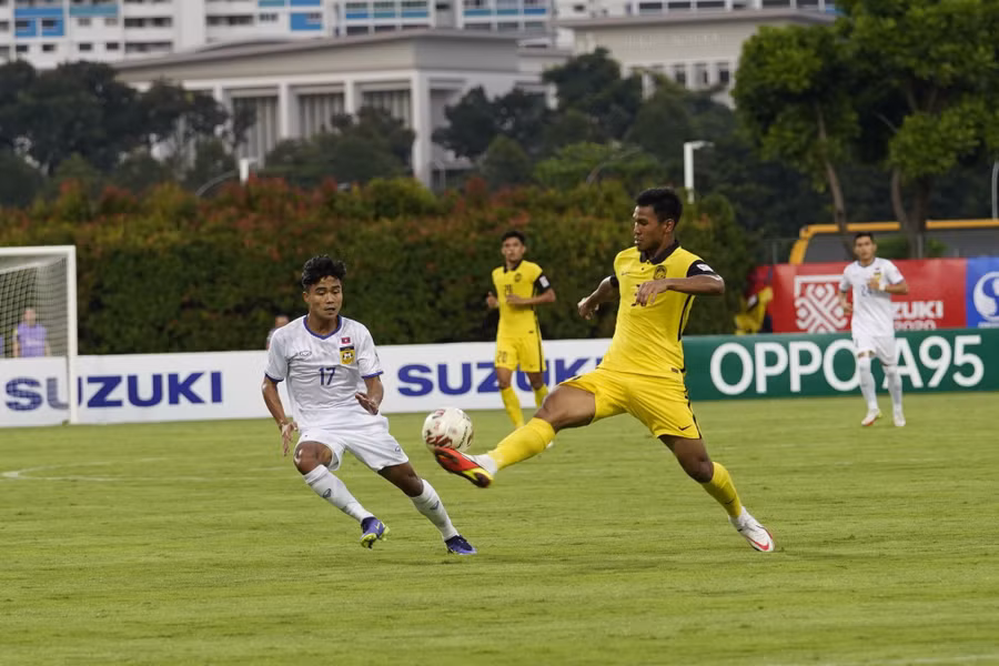 Trận Lào (trái) thua đậm Malaysia cũng bị bàn tán bán độ. Ảnh: LFF