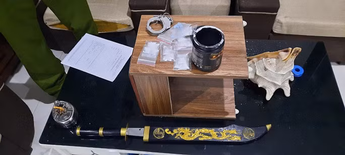  Công an thu giữ nhiều tang vật, trong đó có 1 mã tấu dài nửa mét và 1 chiếc còng số 8