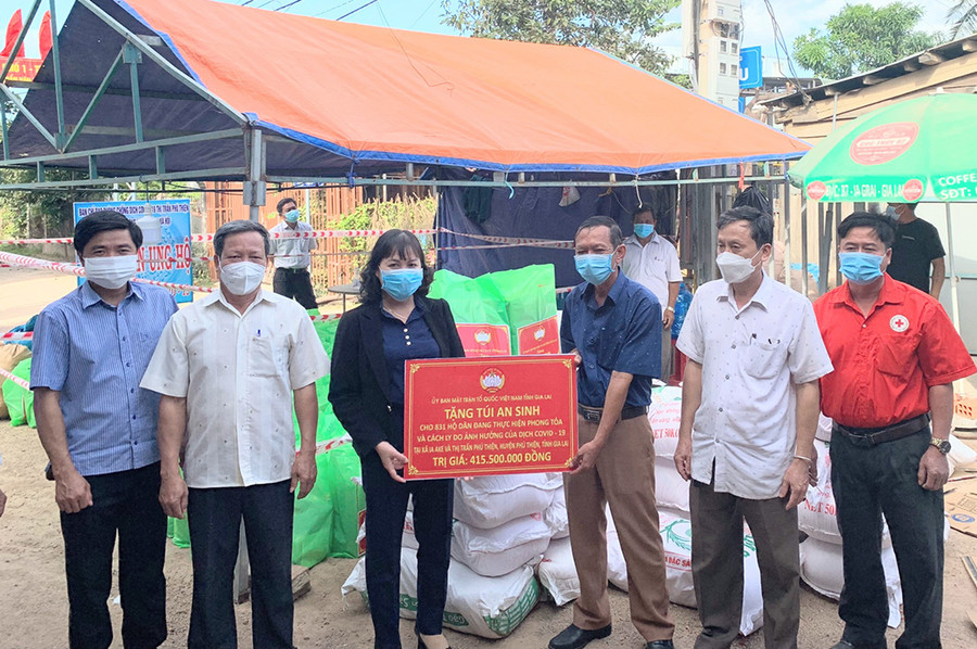 Phó Chủ tịch Ủy ban MTTQ Việt Nam tỉnh Phạm Thị Lan (thứ 3 từ trái sang) trao tặng túi an sinh cho các hộ dân trên địa bàn huyện Phú Thiện ngày 9-12-2021. Ảnh: Lê Đại