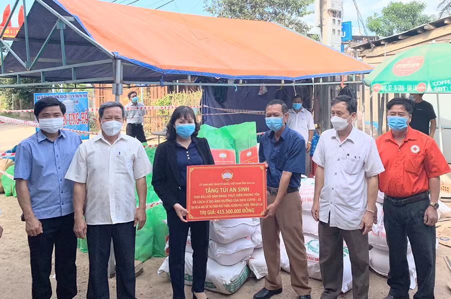 Phó Chủ tịch Ủy ban MTTQ Việt Nam tỉnh Phạm Thị Lan (thứ 3 từ trái sang) trao tặng túi an sinh cho các hộ dân trên địa bàn huyện Phú Thiện ngày 9-12-2021. Ảnh: Lê Đại