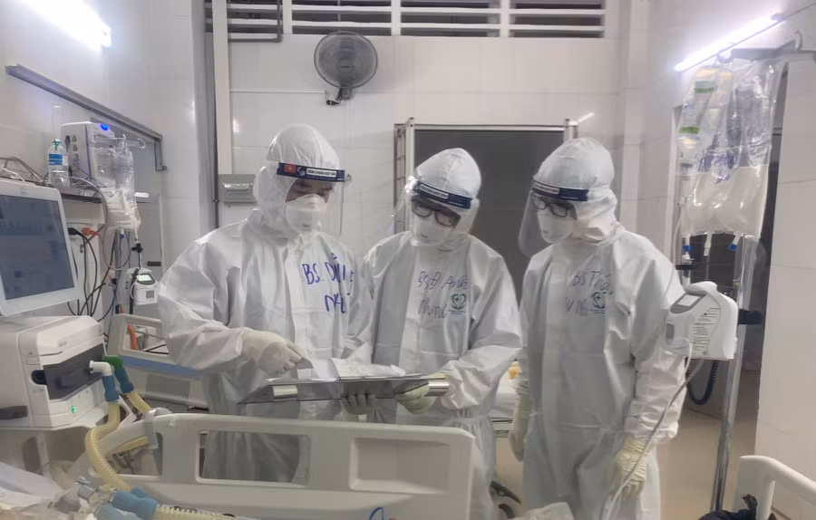  Các y bác sĩ Bệnh viện Nhi TW cùng đồng nghiệp Bệnh viện đa khoa Vĩnh Long trao đổi phương án điều trị người bệnh COVID-19 tại Trung tâm hồi sức tích cực tỉnh Vĩnh Long Ảnh: BSCC