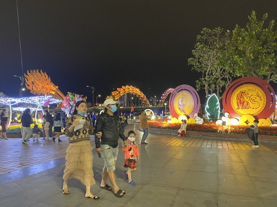 Tại khu vực chân cầu Rồng, nơi có trang trí đường hoa xuân, thu hút người dân đến check-in, chụp ảnh trong thời khắc trước giao thừa năm mới Nhâm Dần