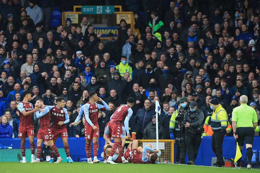 Cầu thủ của Aston Villa nằm sân sau khi bị CĐV Everton ném chai. Ảnh: AFP