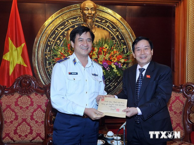 Ông Trần Văn Hằng (phải) trao tiền ủng hộ cho đại diện lãnh đạo Bộ Tư lệnh Cảnh sát biển Việt Nam.