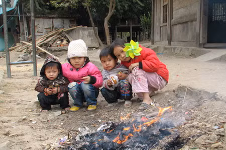 Các em nhỏ ở bản Lát, xã Tam Chung, huyện vùng cao Mường Lát (Thanh Hóa) sưởi ấm bên đống lửa trước nhà