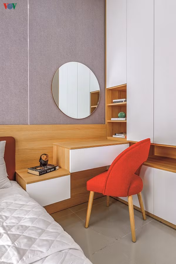 Góc bàn trang điểm với điểm nhấn là chiếc ghế màu đỏ. Tấm gương hình tròn làm tăng sự duyên dáng cho căn phòng./.