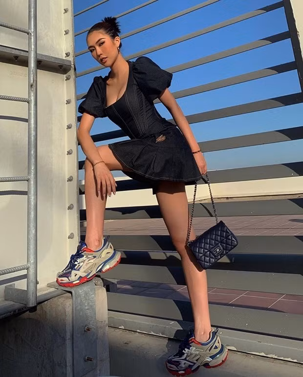 Sân thượng trở thành ''sàn diễn'' của Tường Linh, giúp cô nàng có thước hình sắc nét như tạp chí. Diện đầm denim điệu đà, người đẹp phá cách nhờ kết hợp với giày thể thao. Cặp item vừa tôn vẻ năng động lại không làm mất đi nét gợi cảm.