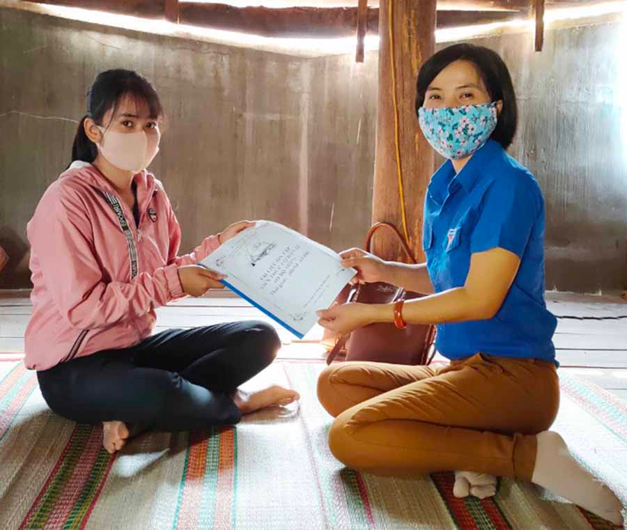 Em Nay Hạ-lớp 12A2, Trường THPT Phan Chu Trinh (trái) nhận tài liệu học tập do cô giáo mang đến tận nhà. Ảnh Hồng Thi