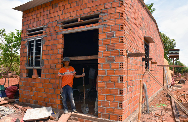 Anh Rơ Mah Thoại (làng Plei ThơGa, xã Chư Don) trước căn nhà đang xây dựng. Ảnh: T.D