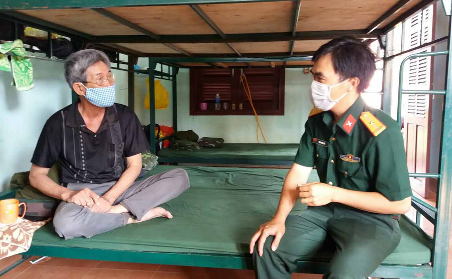Cán bộ động viên ông S. yên tâm ở lại Khu cách ly, chuyện nhà đã có chính quyền địa phương hỗ trợ, giúp đỡ chu toàn. Ảnh: Như Nguyện