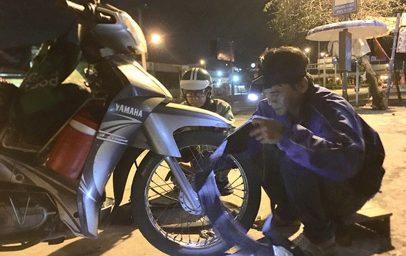 Thấy ruột xe đã mòn, anh Tùng thay luôn ruột mới tặng cho người xe ôm công nghệ vất vả mưu sinh đêm khuya - Ảnh: MY LĂNG Thấy ruột xe đã mòn, anh Tùng thay luôn ruột mới tặng cho người xe ôm công nghệ vất vả mưu sinh đêm khuya - Ảnh: MY LĂNG