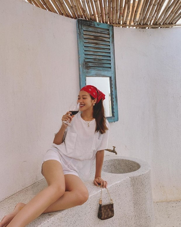 Khả Ngân tận hưởng khoảnh khắc thưởng rượu ở vùng thôn dã. Cô nàng mặc áo thun, quần shorts trắng ton-sur-ton. Chiếc khăn buộc đầu và sắc tay Louis Vuitton được trưng dụng để tạo điểm sáng thú vị.