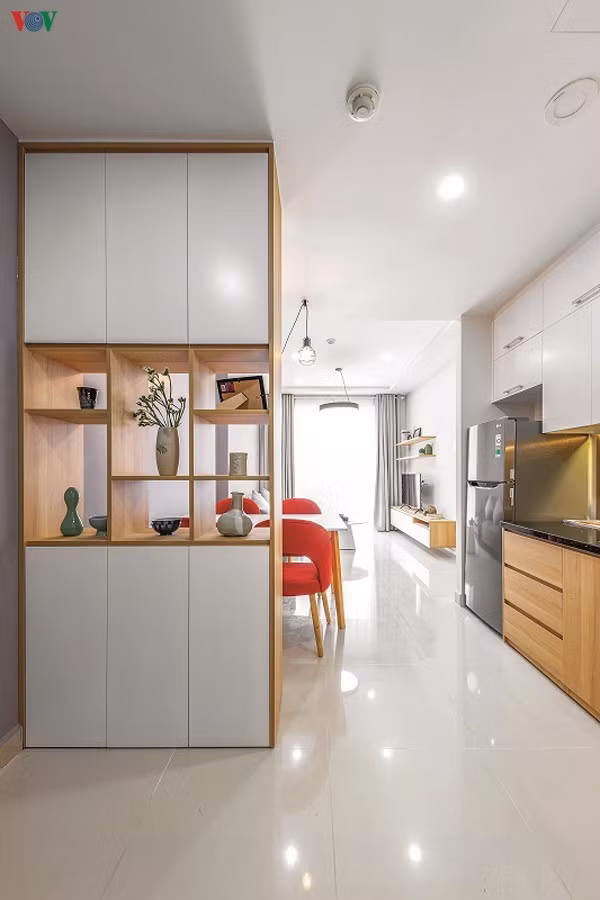 Một chiếc tủ ngăn cách khéo, ước lệ giữa khu vực sảnh và bàn ăn. Các mảng trống làm sự ngăn cách trở nên nhẹ nhàng và tăng cường ánh sáng cho sảnh.