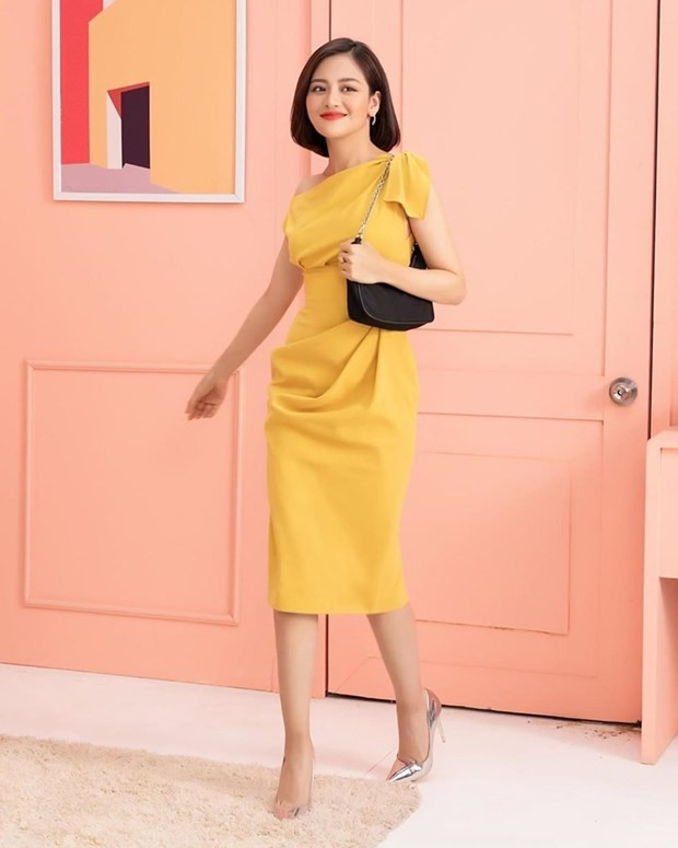 Thùy Anh tỏa sáng rạng rỡ trong chiếc đầm thắt eo, ''nhuộm'' tông vàng bắt mắt. Thiết kế lệch vai mix cùng giày cao gót ánh bạc, điểm xuyết túi quai ngắn biến nữ diễn viên thành quý cô công sở chính hiệu.