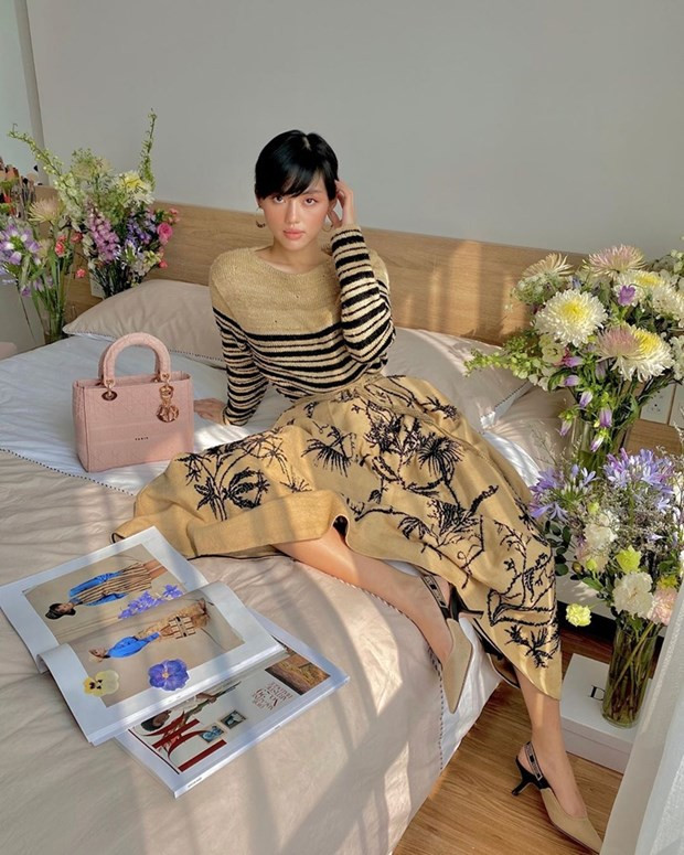 Khánh Linh biến phòng ngủ thành studio với đủ loại hoa đầy màu sắc. Fashionista 9X lan tỏa phong cách Pháp khi diện các thiết kế từ bộ sưu tập Xuân Hè 2020 của Dior. Đôi giày slingback cùng tông, kết hợp túi Lady D-Lite là cặp phụ kiện nhấn hoàn hảo cho tổng thể trang phục.
