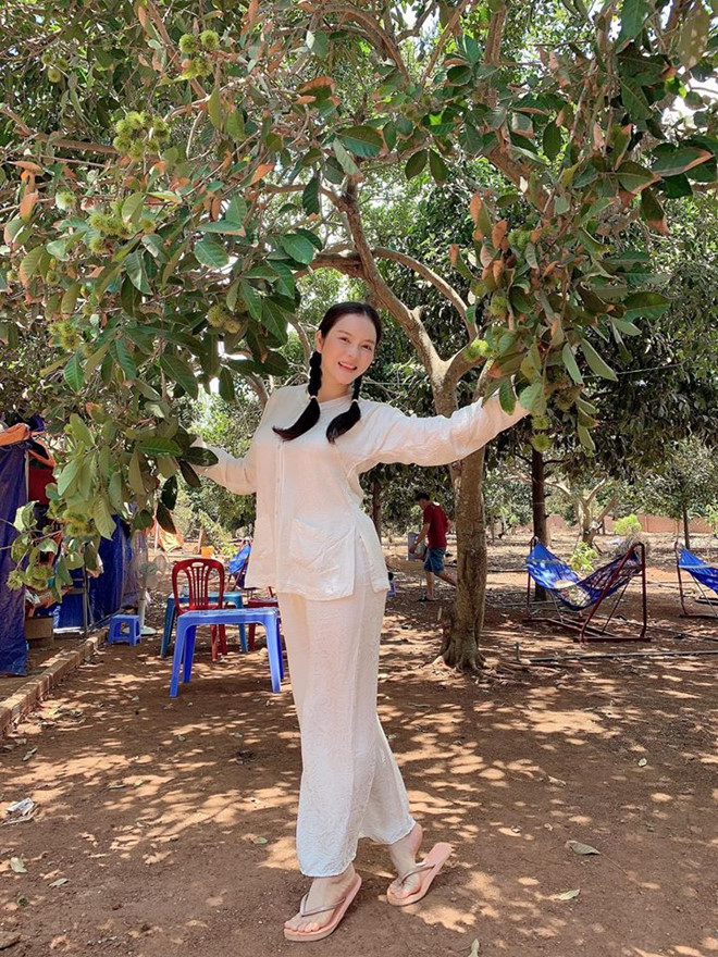 Mới đây, Lý Nhã Kỳ khiến fan thích thú khi diện trang phục bà ba trắng, tết hai bím tóc khoe nhan sắc trẻ trung, mộc mạc tại vườn trái cây. ẢNH: FBNV