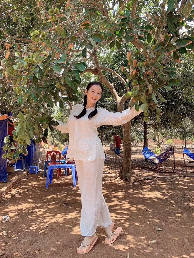 Mới đây, Lý Nhã Kỳ khiến fan thích thú khi diện trang phục bà ba trắng, tết hai bím tóc khoe nhan sắc trẻ trung, mộc mạc tại vườn trái cây. ẢNH: FBNV