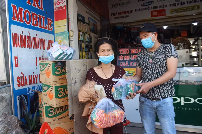 Anh Sơn trao những gói mì tôm cho người phụ nữ có hoàn cảnh khó khăn trên địa bàn TP.Đà Lạt.