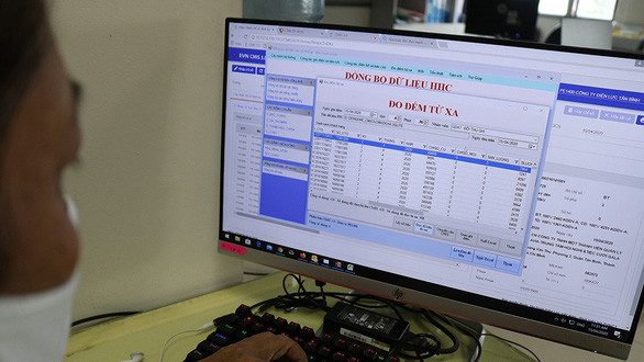 Nhân viên Công ty Điện lực Tân Bình (Q.Tân Bình, TP.HCM) lấy số liệu điện tiêu thụ hằng tháng của khách hàng thông qua phần mềm đo đếm từ xa - Ảnh: NGỌC PHƯỢNG