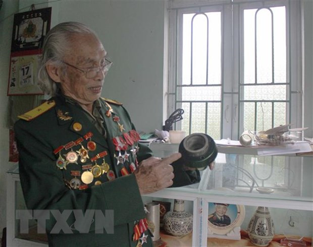 Anh hùng Trần Kim Xuân với những kỉ vật chiến tranh. (Ảnh: Nguyễn Thảo/TTXVN) Anh hùng Trần Kim Xuân với những kỉ vật chiến tranh. (Ảnh: Nguyễn Thảo/TTXVN)