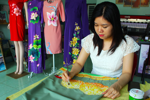 Chị Nguyễn Thanh Nhàn vẽ tranh lên trang phục để bán. Ảnh: P.L