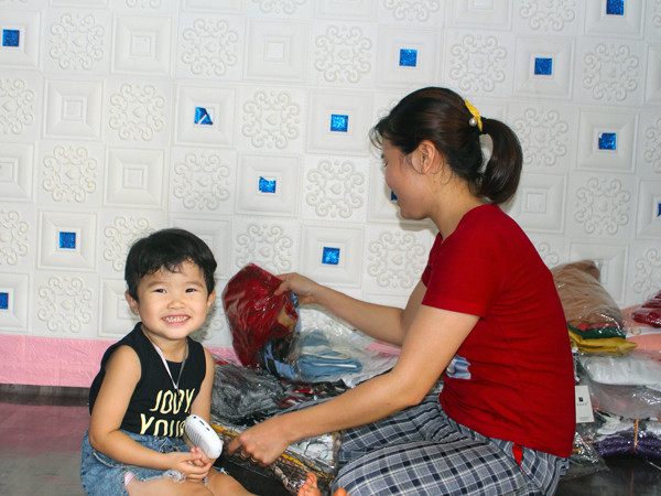 Con gái chị Đặng Thị Trang (Chư Sê) thích thú nghe loa trong khi mẹ làm việc. Ảnh: N.G