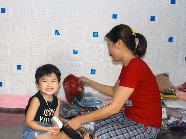 Con gái chị Đặng Thị Trang (Chư Sê) thích thú nghe loa trong khi mẹ làm việc. Ảnh: N.G