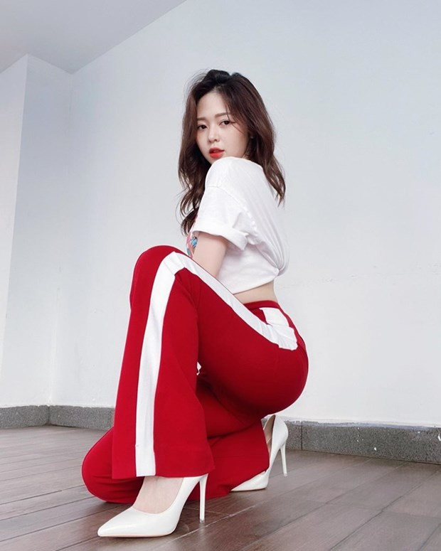 Liz phô diễn vòng 3 nóng bỏng với quần ống rộng cạp và áo thun hở eo. Giày pumps trắng là phụ kiện giúp cô nàng ''ăn gian'' chiều cao xuất sắc.