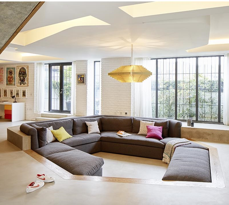 Đệm sofa của phòng khách được đặt ngang bằng với bề mặt của tường gỗ màu nâu bao quanh. Đệm sofa của phòng khách được đặt ngang bằng với bề mặt của tường gỗ màu nâu bao quanh.