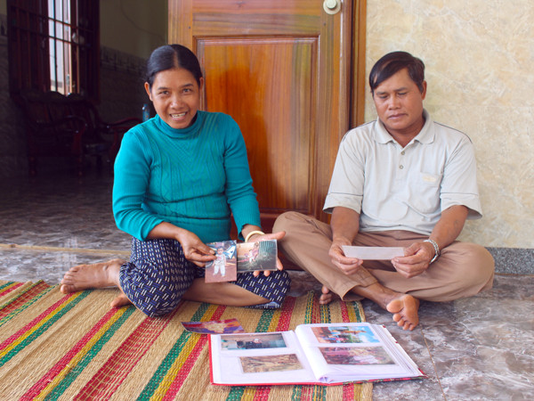  Vợ chồng ông Rơ Lan Hít và bà Rơ Châm Phêm xem lại những hình ảnh thuở nhỏ của 2 con gái nuôi. Ảnh: T.B